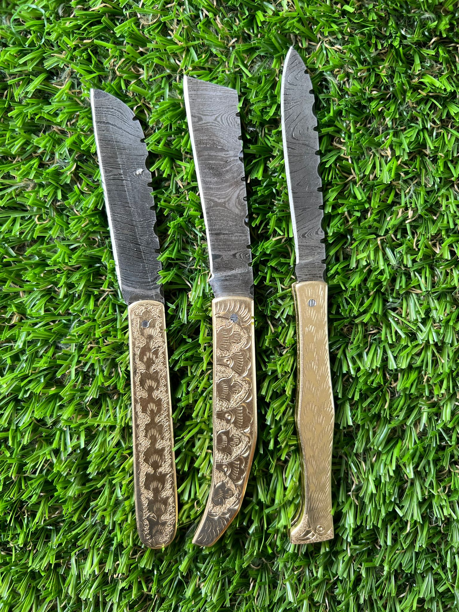 Damascus steel folding pocket knife with engraved brass handle
