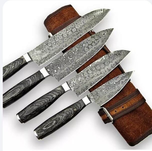 Set of four Damascus steel chef knives laid out with a rolled leather bag
